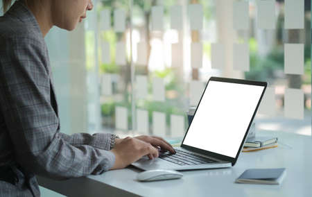 Focused businesswoman using laptop computer at bright modern office.の写真素材