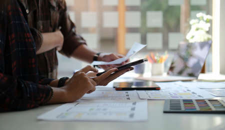 Cropped shot of web designers team discussing and working together to develop mobile responsive...