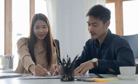 Two young businesspeople working and discussing on new project planning together.の写真素材