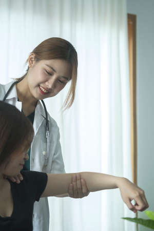 Young physiotherapist working with  patient in bright clinic. Physiotherapy rehab, injury recovery...