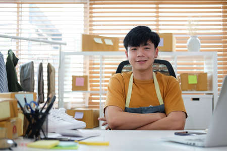 Startup small business entrepreneur sitting with crossed arms and looking confidently to camera. Startup, Online selling, E-commerce concept.の写真素材