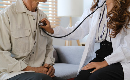 Cropped shot female doctor holding stethoscope listen to senior patient heart. Medical healthcare...