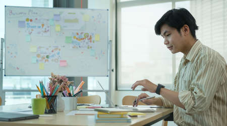 Cropped shot of young creative man using computer laptop at office desk.