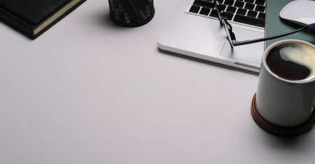 From above view laptop computer, wireless mouse, notebook and coffee cup on white table with copy space.の写真素材