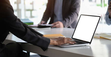 Cropped shot businessman using laptop computer at meeting.の写真素材
