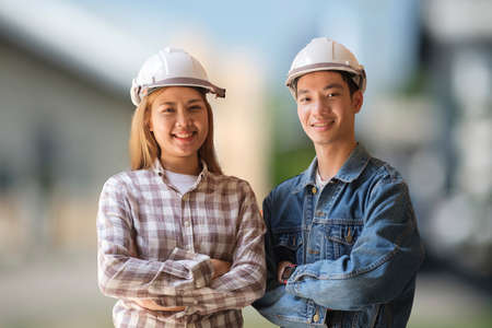 Confident architects wearing safety helmet standing at construction site.の写真素材