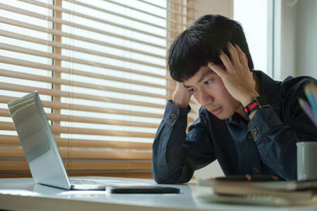 Unhappy businessman covering face with hand, feeling stress, headache, migraine, having problems...