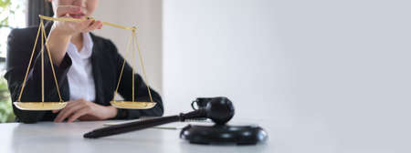 Confident lawyer with small golden justice scale and wooden gavel.  Legal services, advice, justice...