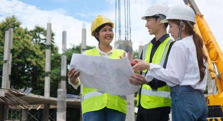 Engineer team in protective helmets and vests inspecting construction site. Engineering and architecture concept.の写真素材