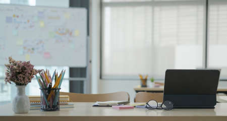 Laptop, glasses and supplies on wooden table in corporate office.の写真素材