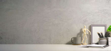 Home office desk with notebook, coffee cup, potted plant and wooden dummy on white table.  Copy...