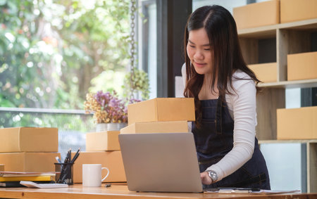 Small business entrepreneur using laptop computer, checking order from customer. Startup small business, Online selling, E-commerce concept.の写真素材