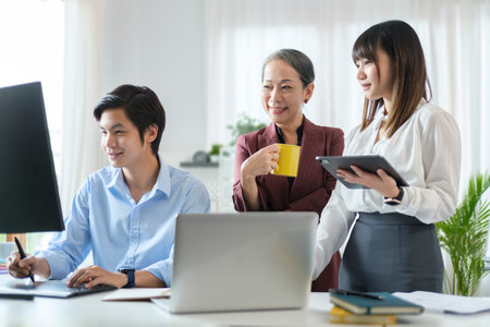 Mature businesswoman having a discussion with her team, discussing corporation project together in office.の写真素材