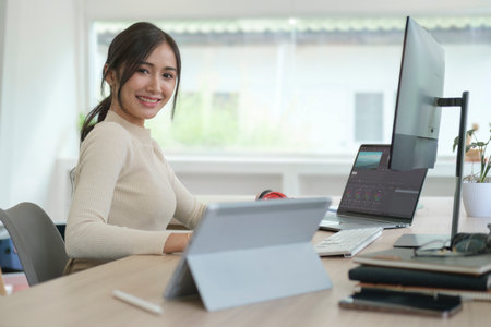 Female video editor working on professional computer in creative studio office.の写真素材