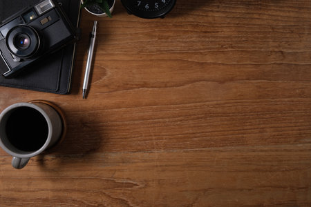 From above view of retro camera, coffee and notebook on wooden table. Top view with copy space.の写真素材