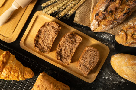 Freshly baked delicious bread and wheat on rustic wooden table. Close up view.