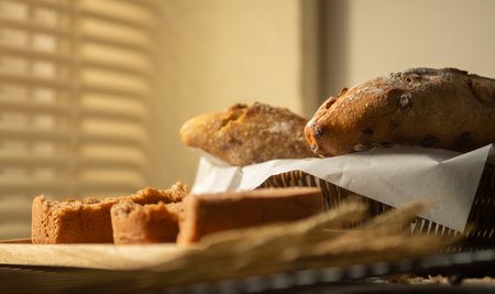 Homemade loaf of rustic traditional bread with wheat grain ear on wooden table.