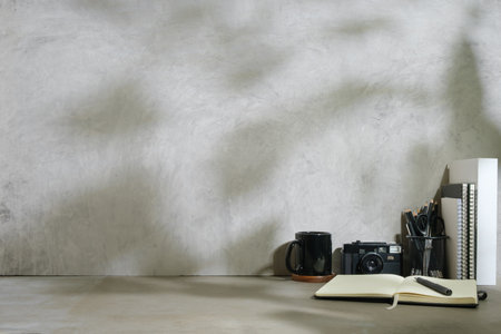 Home office desk with retro camera, coffee cup, pencil holder and books. Copy space for your text.