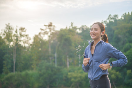 Fitness woman  jogging, enjoying fitness and healthy lifestyle with beautiful mountain view at sunset in background.の写真素材