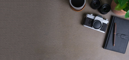 Camera, notebook and coffee cup on grey table. Copy space for your advertise text or information...