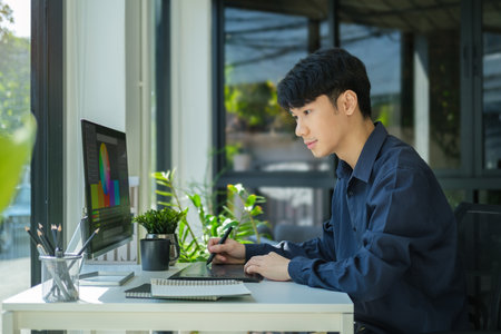 Young asian male graphic designer working  with color swatch samples at modern office.の写真素材