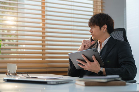 Successful young businessman in formal wear looking through windows resting or thinking about startup, planning new projects.の写真素材