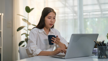 Portrait of female finance investment analyst checking project management report on her laptop computer.の写真素材