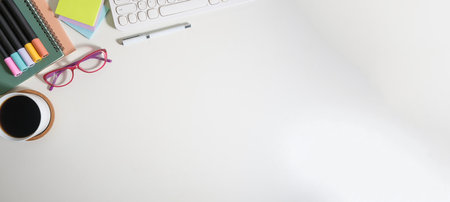 Top view of cup of coffee, glasses, books and keyboard on white working desk. Copy space for your text.の写真素材