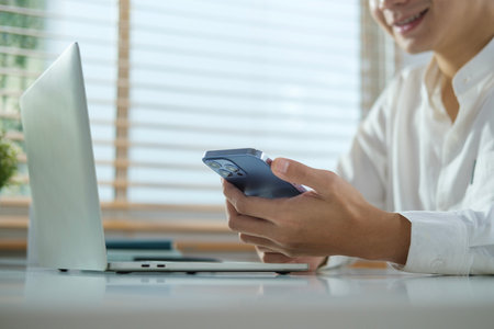 Cropped image of smiling man messaging in social media or communicating online in application.の写真素材
