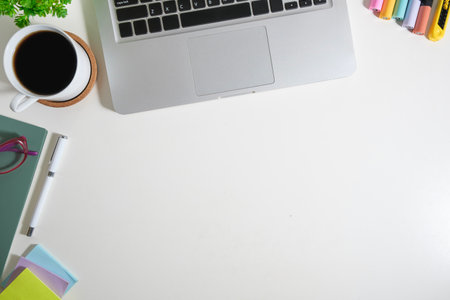 Top view of white working desk with laptop and various office supplies. Copy space for your text.の写真素材