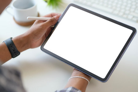 Close up view of man hand holding digital tablet over white working desk. Blank screen forの写真素材