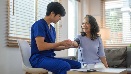 Male caregiver measuring blood pressure of a senior woman. Hypertension, medical and health care...