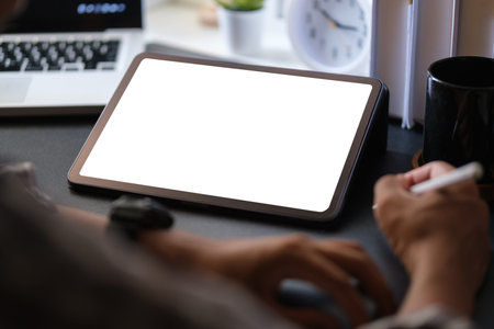Cropped shot businessman holding stylus pen and writing on display of digital tablet.の写真素材