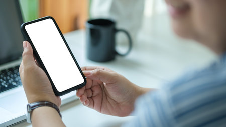 Close up view female holding mock up mobile phone with blank screen.