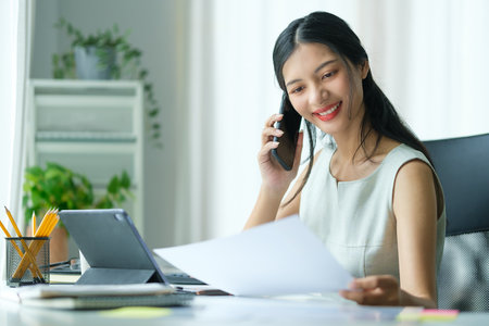 Professional businesswoman having phone conversation with her business partner.の写真素材