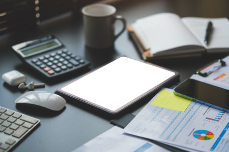 Business graphs, charts, digital tablet and calculator on office desk. Financial development, banking account and statistics.の写真素材