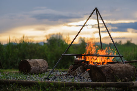 Campfire at touristic camp with beautiful sunset sky.