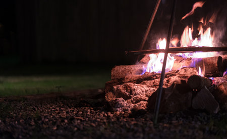 Bonfire with burning firewood at touristic camp at night. Camping, recreation, outdoor activities concept.の写真素材