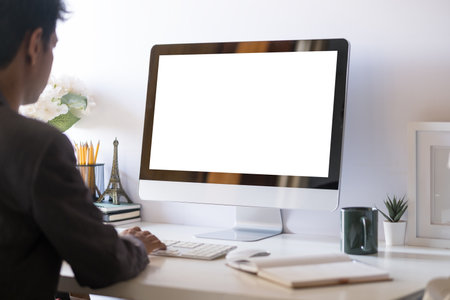 Young businessman sitting at comfortable workplace and using computer.の写真素材