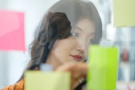 Smiling female graphic designer working on nee project at creative office.