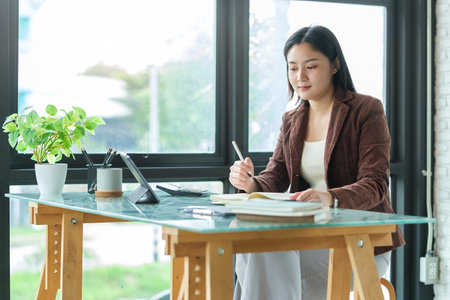 A businesswoman working on new project with laptop computer in modern office.の写真素材