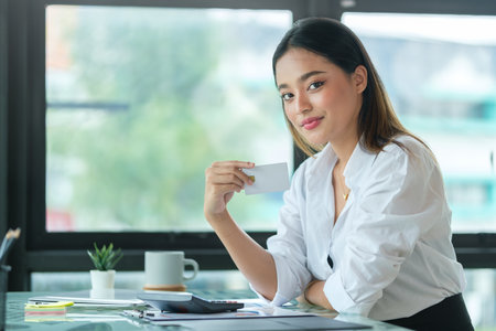 Portrait of attractive female employee taking a break, drinking coffee at workplace..の写真素材