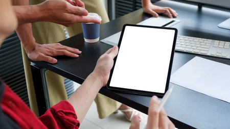 Businessman holding digital tablet sharing information, planning work with his colleague.の写真素材
