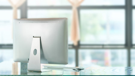 Back view of computer monitor with keyboard on office desk in modern office.の写真素材