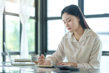 Beautiful young businesswoman working with financial reports at her workplace.の写真素材