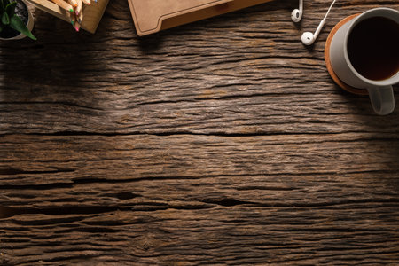Simple workplace desk with notebook, computer keyboard, mouse and cup of coffee on wooden table. Top view with space.の写真素材