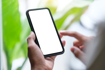 Hands holding smart phone with blank screen for your website design project.の写真素材