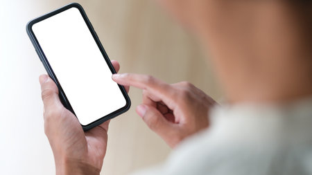 View over shoulder of man hands holding smart phone. Empty screen for your advertise text.の写真素材