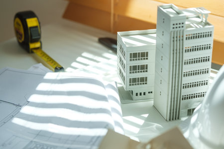Architectural model of  residential buildings on desk with technical tools and blueprints. Building, construction and real estate business.の写真素材