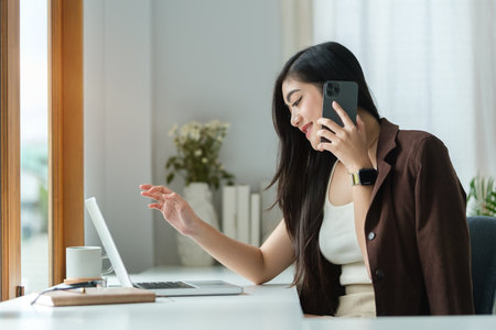 Professional businesswoman having phone conversation with her business partner.の写真素材